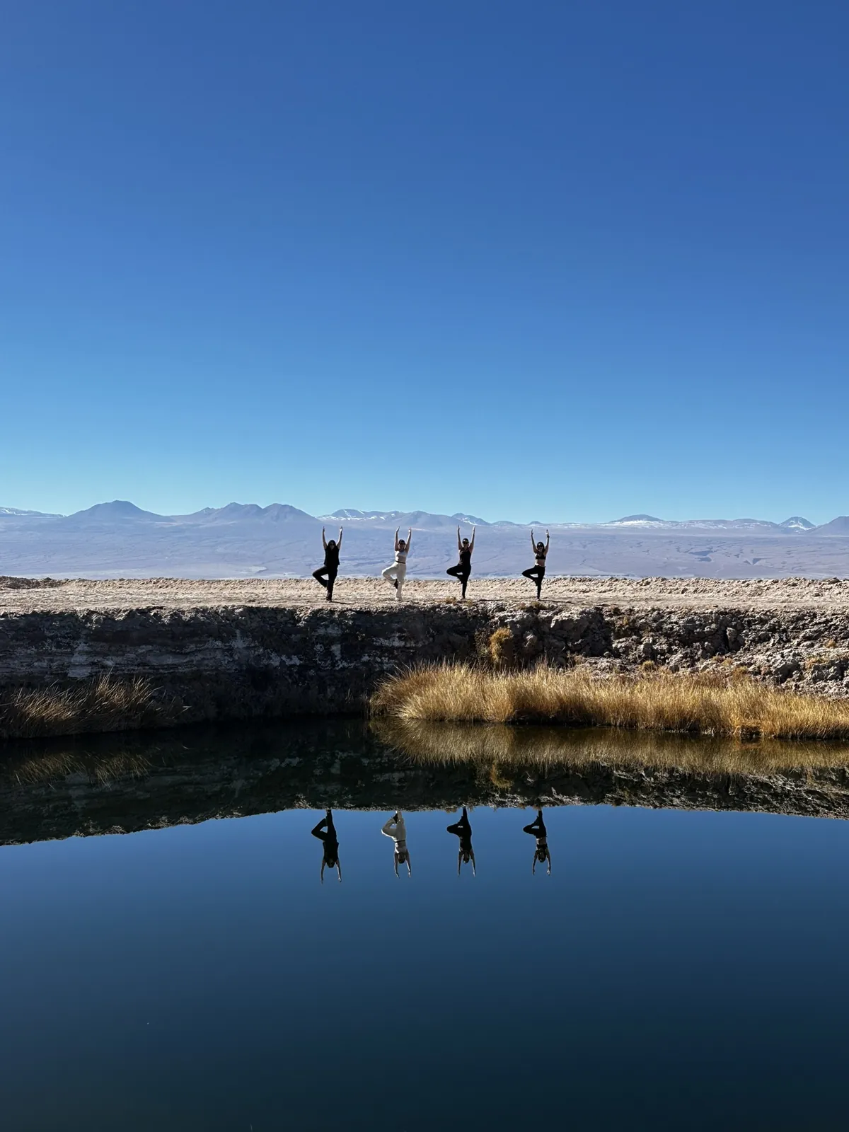 Grupo haciendo yoga frente a Ojos del Salar, Atacama